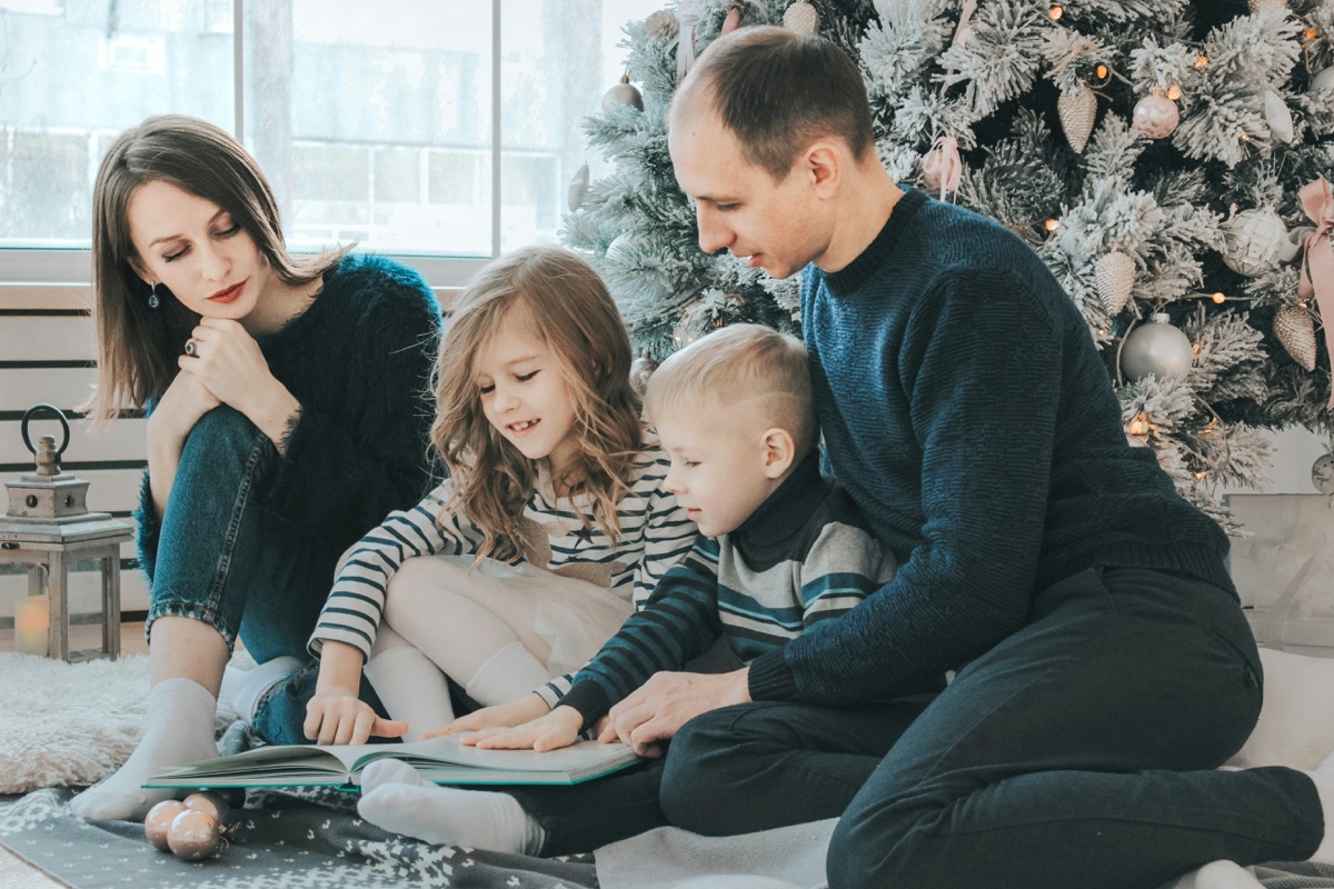 A family reading a memory book together at home
